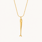 Pescara long fish pendant necklace in polished gold on a warm ivory background.
